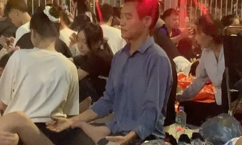 Người đàn ông tập yoga giữa biển người chờ xem diễu binh