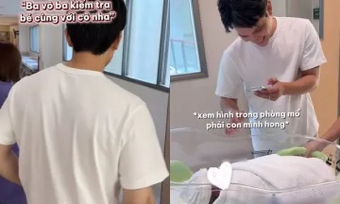 Chồng Á hậu Chế Nguyễn Quỳnh Châu cẩn thận xem hình trên điện thoại trước khi nhận con từ điều dưỡng bệnh viện