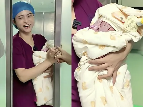Bé sơ sinh vừa chào đời được bác sĩ bế ra ngoài gặp gia đình, đứa trẻ liên tục lấy tay che mặt