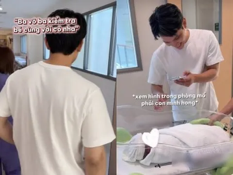 Chồng Á hậu Chế Nguyễn Quỳnh Châu cẩn thận xem hình trên điện thoại trước khi nhận con từ điều dưỡng bệnh viện